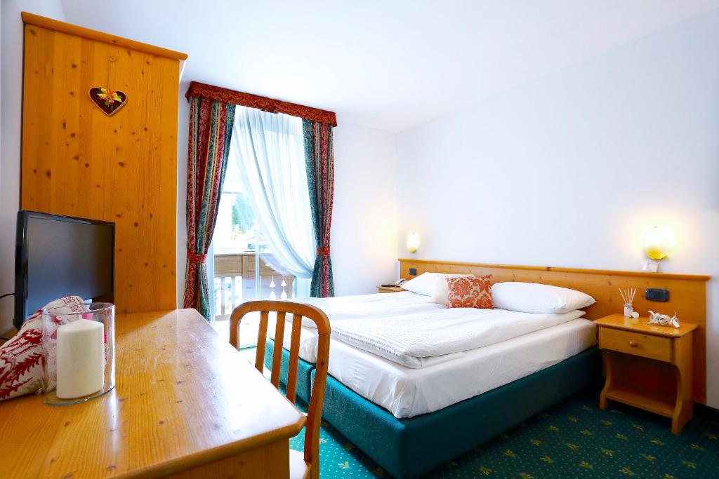 Łóżko lub łóżka w pokoju w obiekcie Alp Hotel Dolomiti