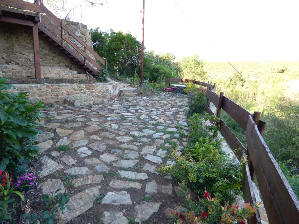 a stone path with a fence and flowers at Mas de la Fariole in Caixas
