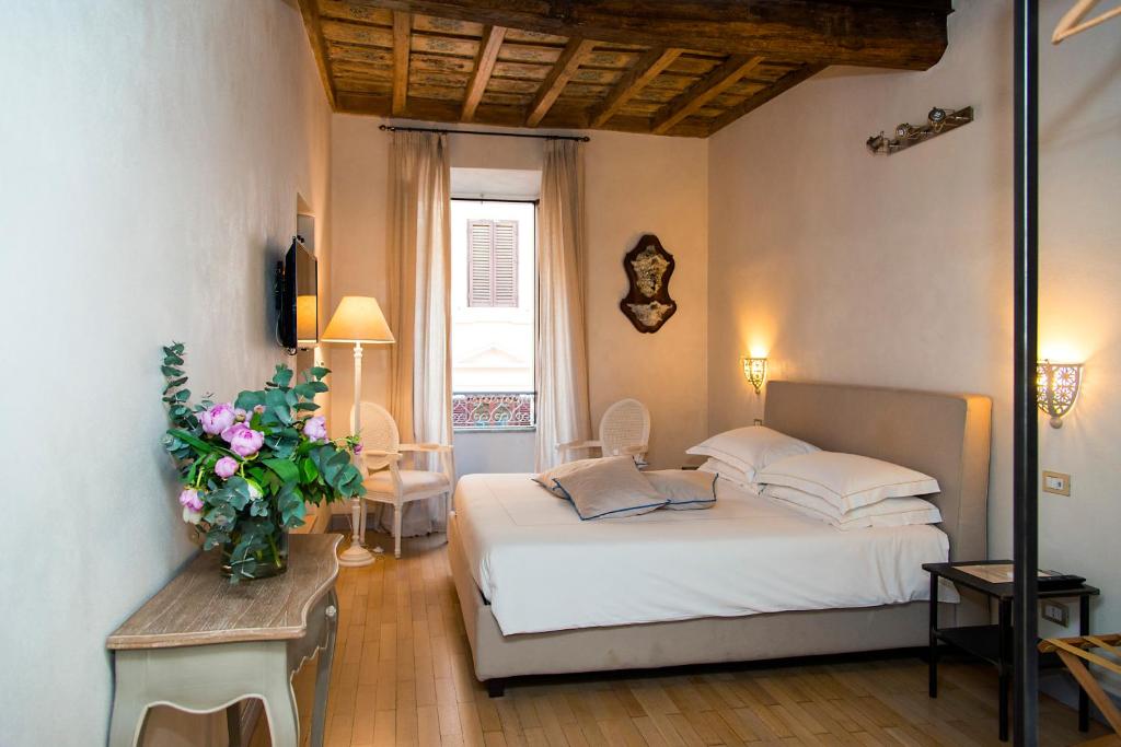 een slaapkamer met een bed en een vaas met bloemen bij Rome Frattina27 in Rome