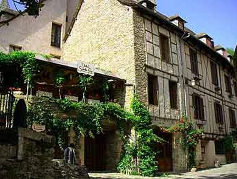 - un grand bâtiment en pierre avec du lierre dans l'établissement Hôtel Sainte Foy, à Conques