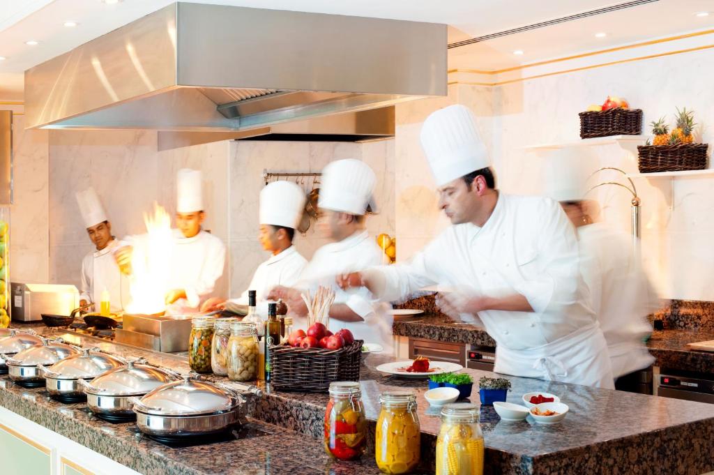 a group of chefs in a kitchen preparing food at Kempinski Hotel Palm Jumeirah in Dubai