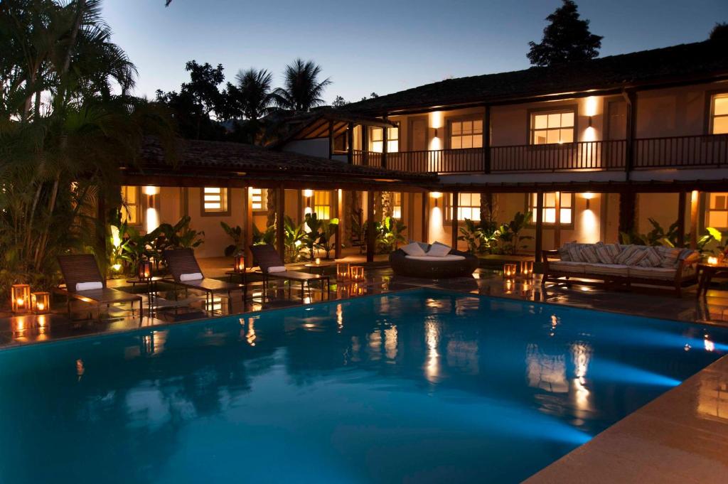 a hotel room with a pool and a balcony at Pousada Literária de Paraty in Paraty