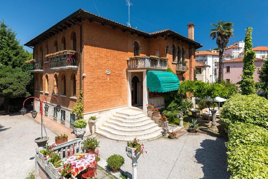 un gran edificio de ladrillo con balcón y escaleras en Villa Albertina en Venice-Lido