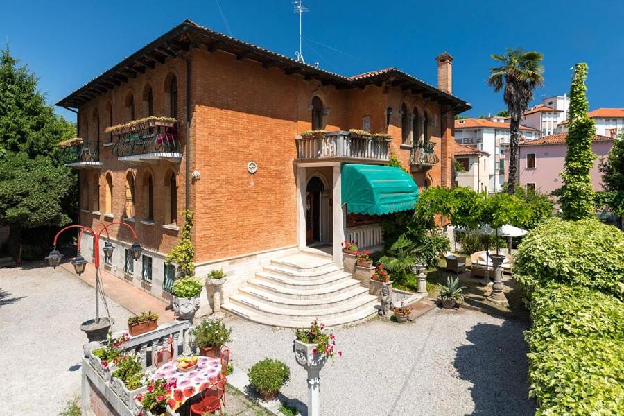 a large brick building with a balcony and stairs at Villa Albertina in Venice-Lido