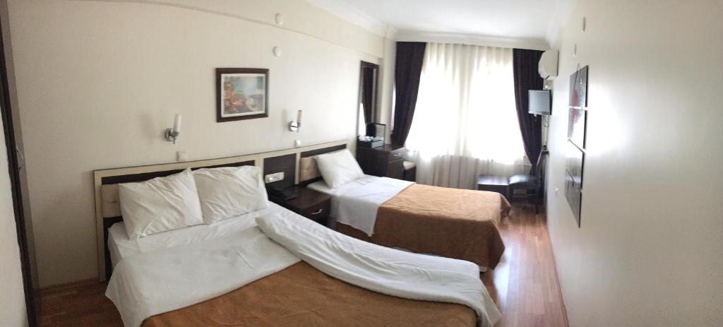 una camera d'albergo con due letti e una finestra di Hotel Grand Mark a Istanbul