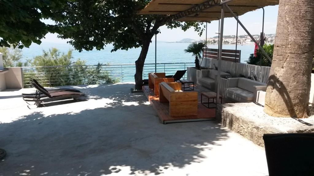 a group of chairs sitting under a pavilion near the water at Bozikovic 365 in Podstrana