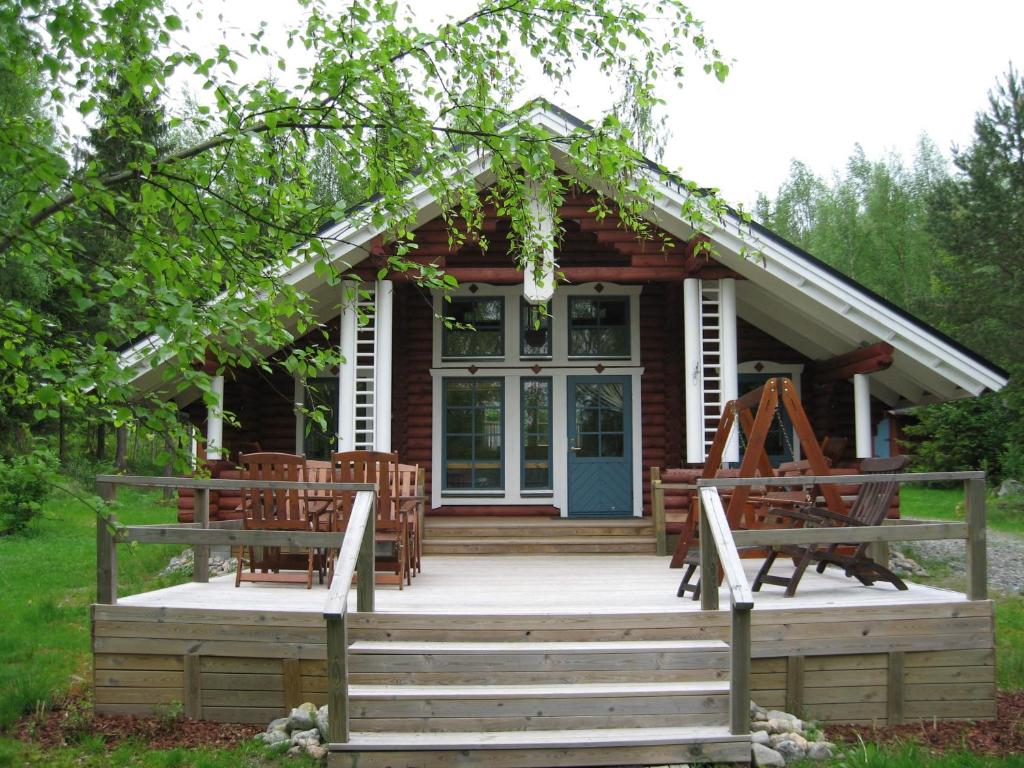 Cabaña de madera con porche y puerta azul en Mökki Eteläranta en Mikkeli