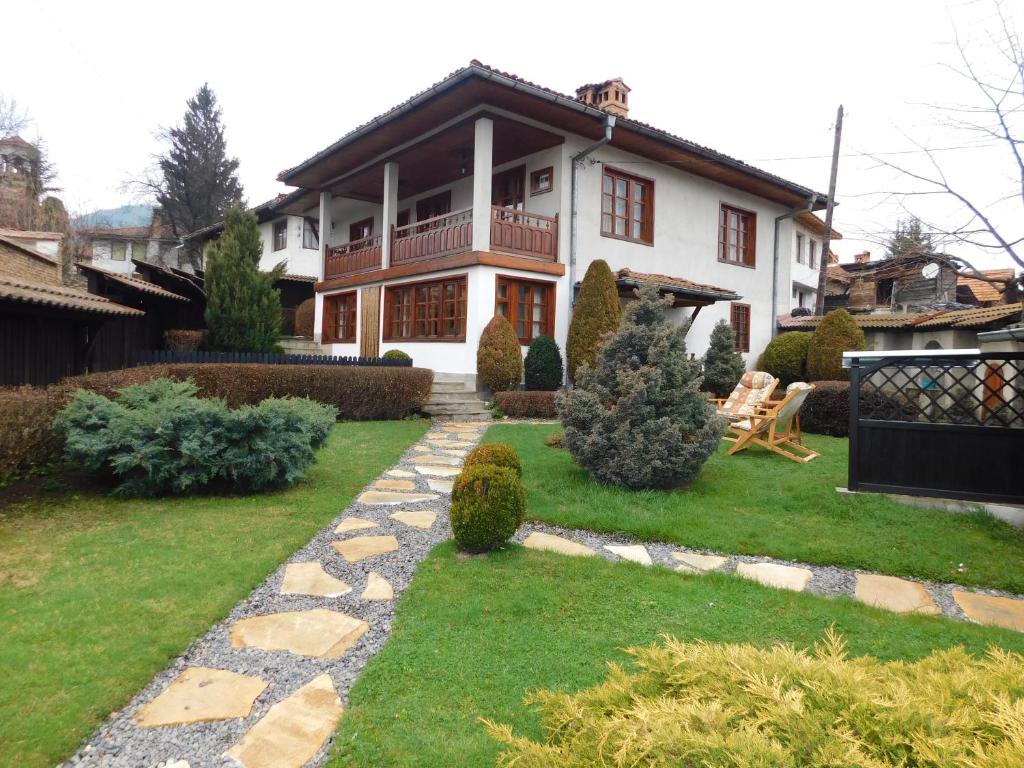 ein Haus mit einem Gehweg vor einem Hof in der Unterkunft Family Vacation Home Topolnitza in Kopriwschtiza
