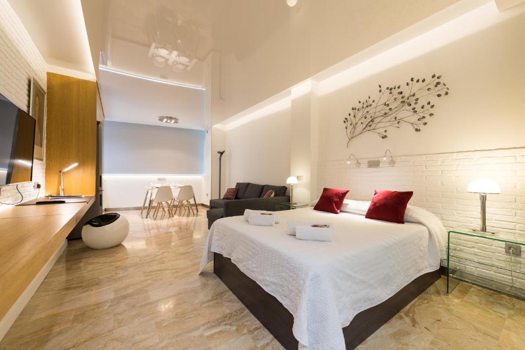 a bedroom with a bed and a living room at Suites Garden Loft Munch in Las Palmas de Gran Canaria