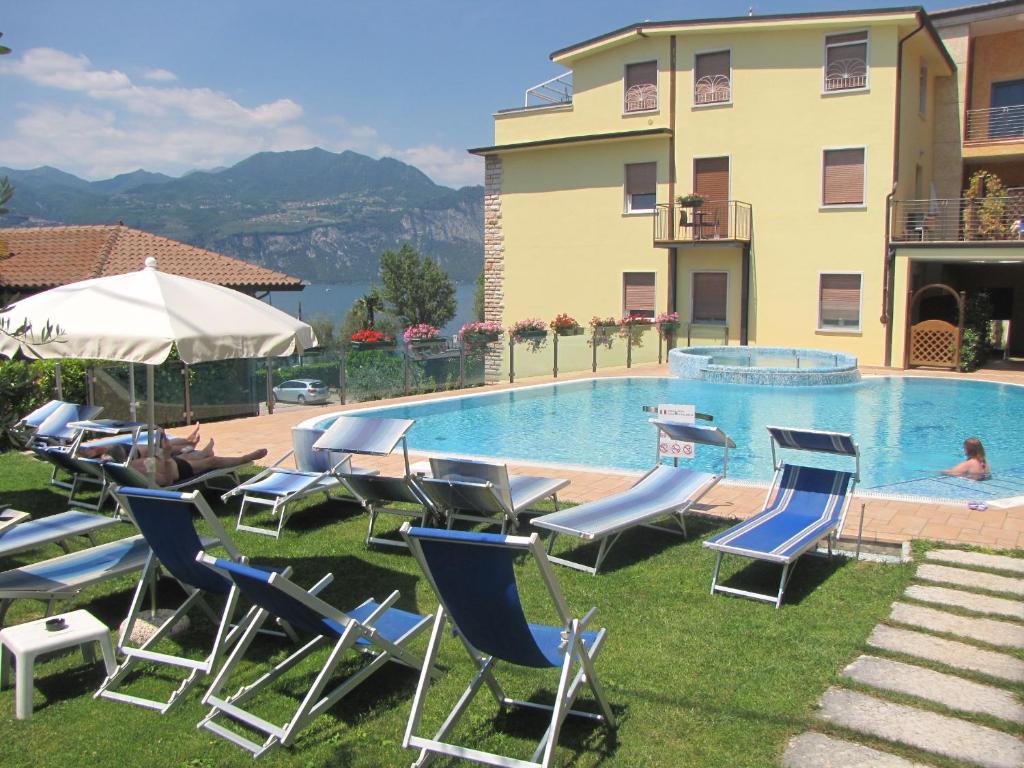 a group of lawn chairs and a swimming pool at Hotel Garni Rosmari in Brenzone sul Garda