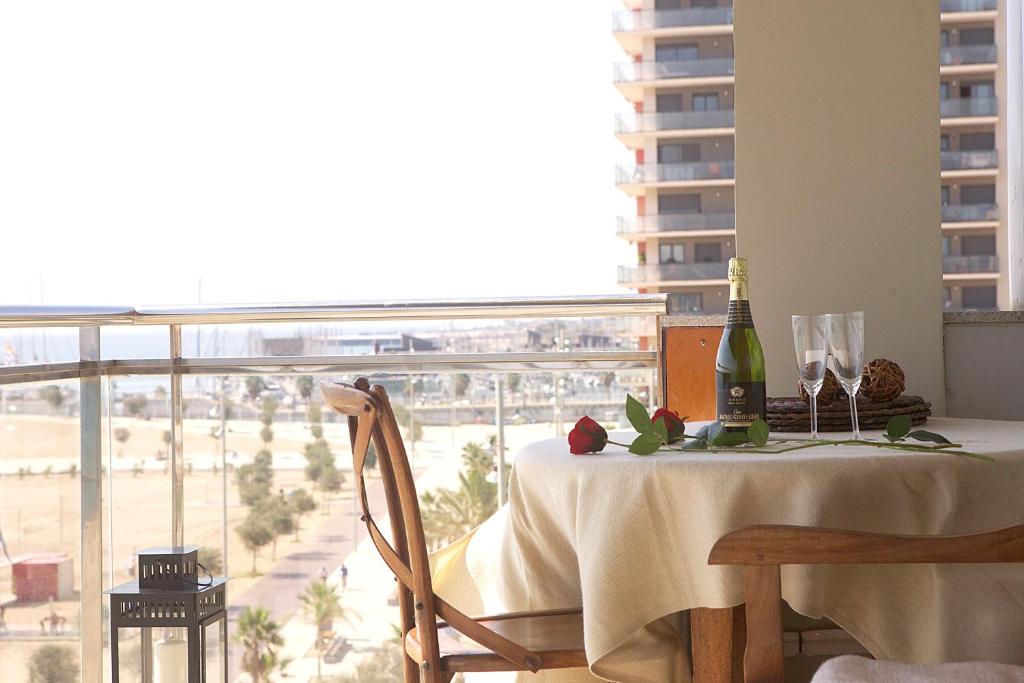 バダロナにあるGreat Sea-Side Barcelona Apartmentのワイン1本とグラス1杯付きのテーブル