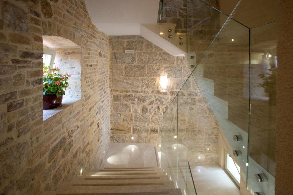 a bathroom with stairs and a glass shower at Aspalathos Residence in Split