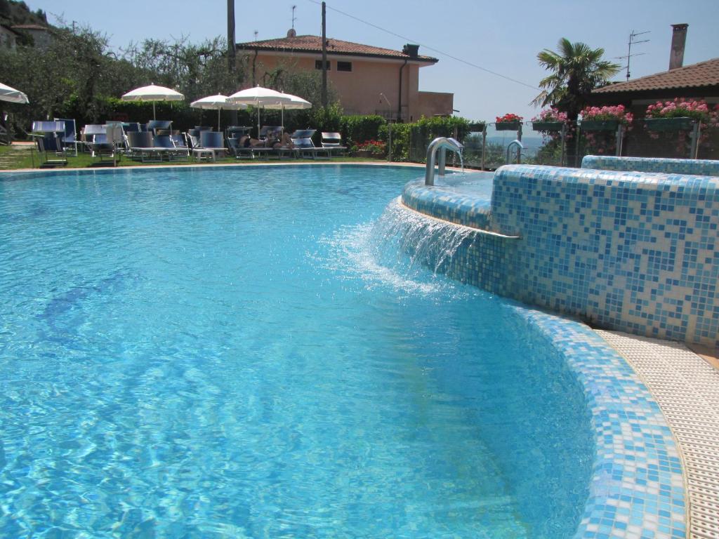 uma piscina com uma piscina de azulejos azuis em Residence Villa Margherita em Brenzone sul Garda