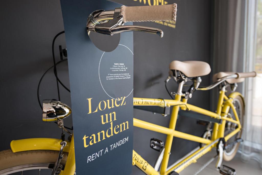 a yellow bike parked next to a stand with a sign at Golden Tulip Marseille Euromed in Marseille