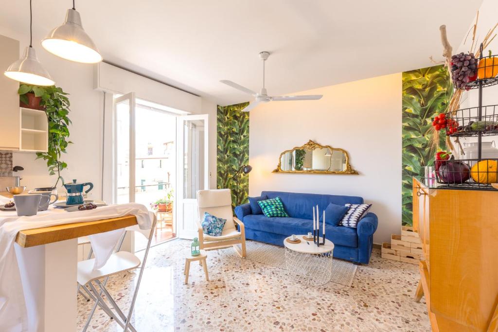 uma sala de estar com um sofá azul e uma mesa em Maison Brigitte - Solemar Sicilia em Santa Flavia