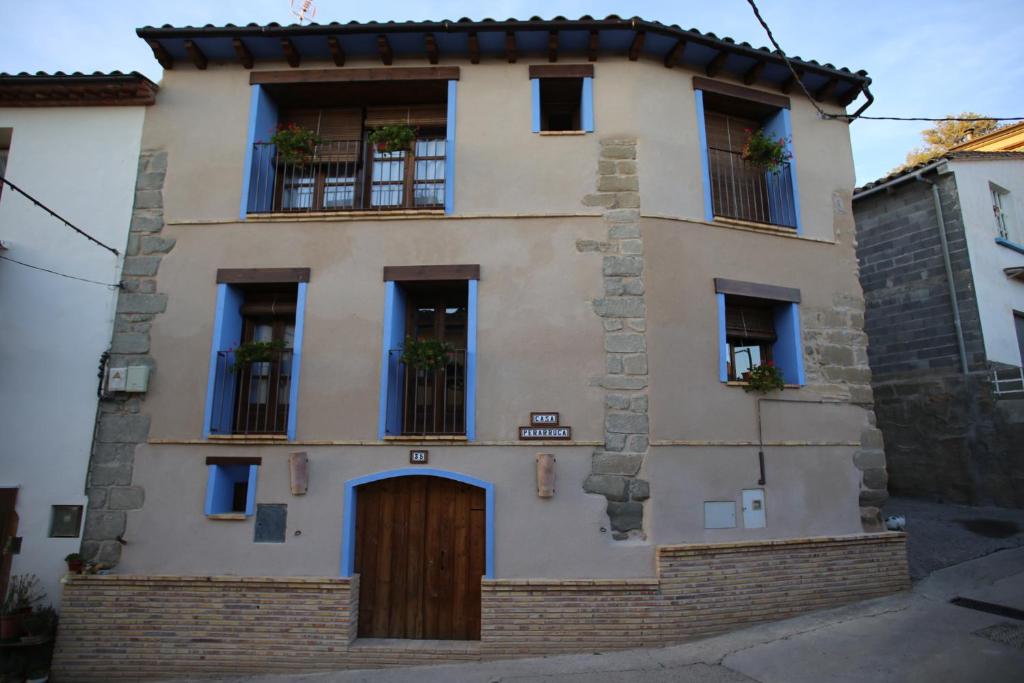 ein Gebäude mit blauen Fenstern und einer Tür in der Unterkunft Casa Perarruga in Pozán de Vero