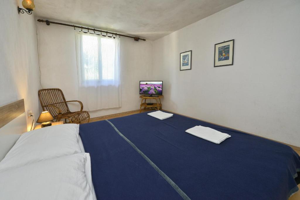 1 dormitorio con 1 cama con manta azul en Villa Funtana, en Funtana