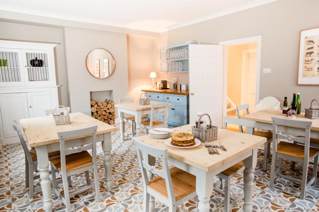 a dining room with tables and chairs and a kitchen at The Old Rectory in Campsea Ashe