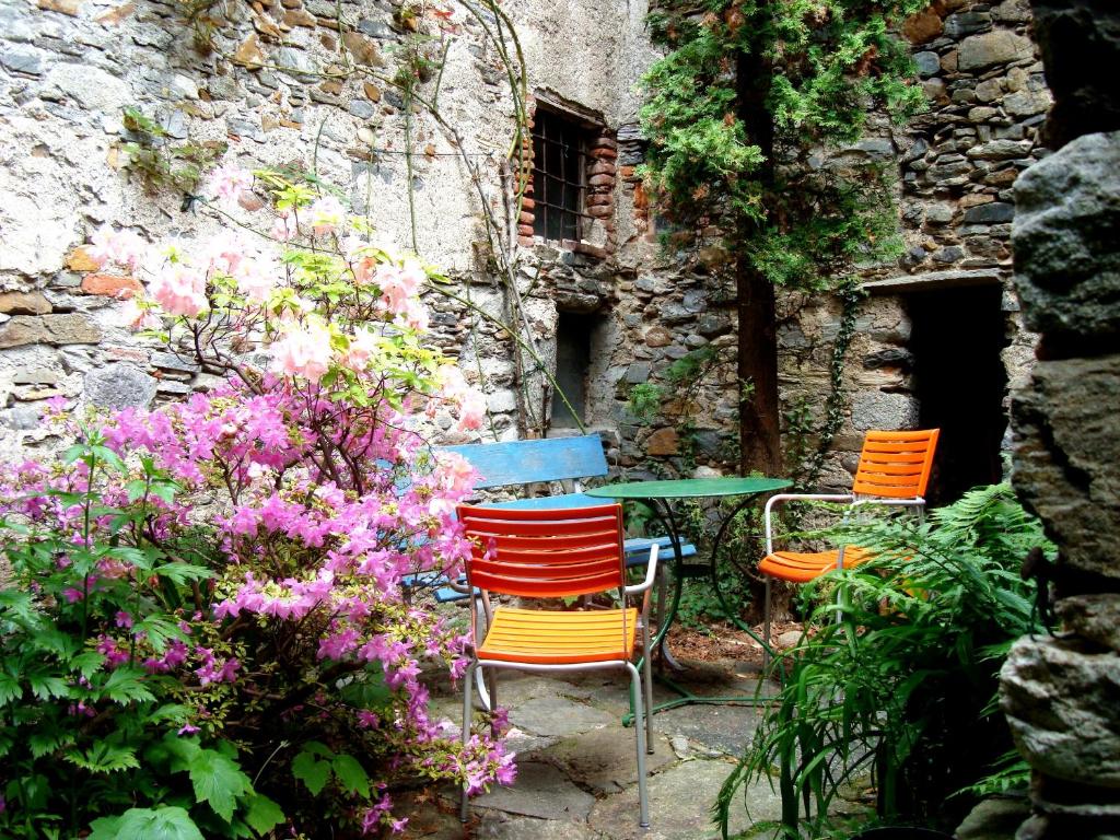 un tavolo con sedie e fiori in giardino di CASA LEONE - Apartements im Alto Malcantone a Breno