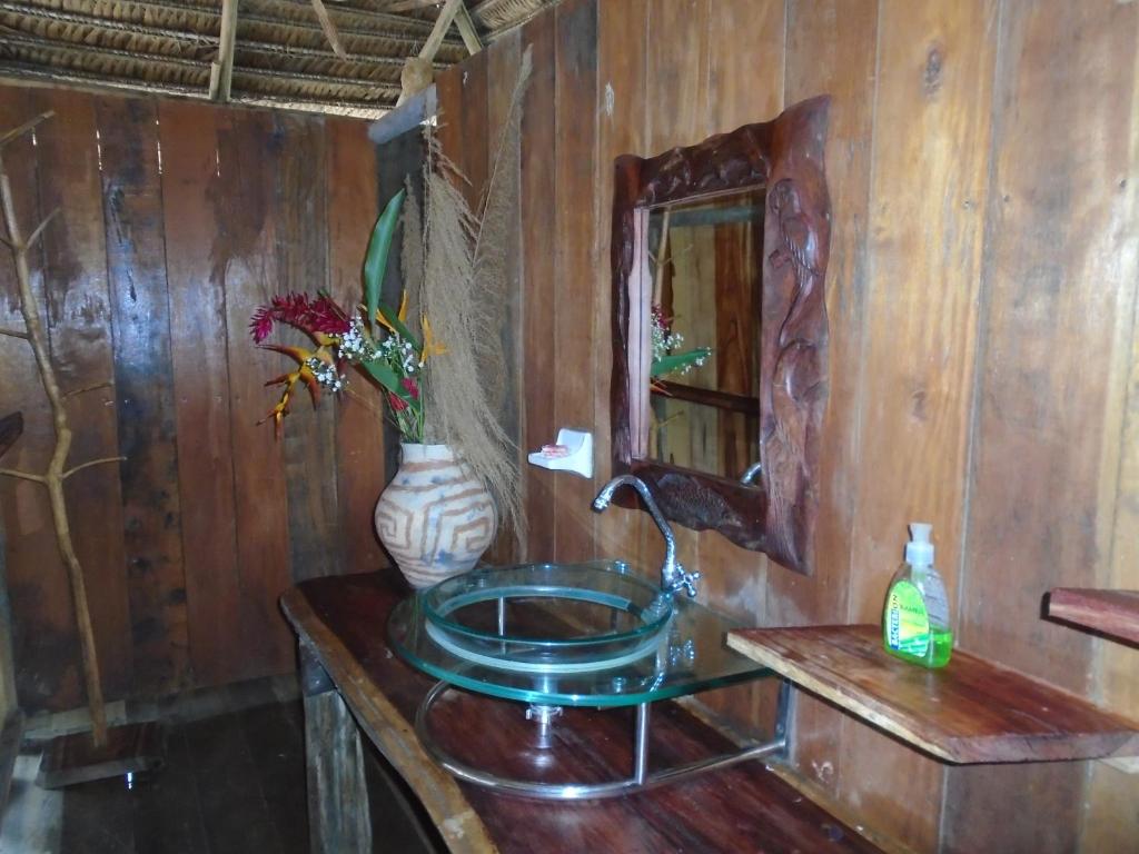 a wooden bathroom with a sink and a mirror at Cabaña Flotante Kurupira in Leticia
