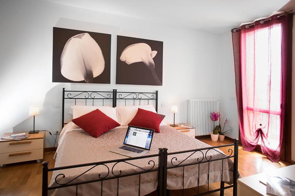 sypialnia z łóżkiem z laptopem w obiekcie Verona Class ApartHotel "Residenze del Cuore" w Weronie