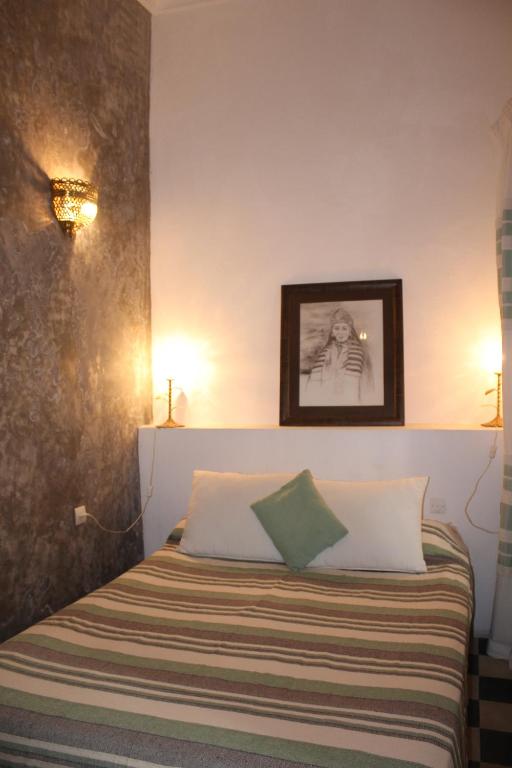 a bedroom with a bed with two pillows at Riad Arous Chamel in Tangier