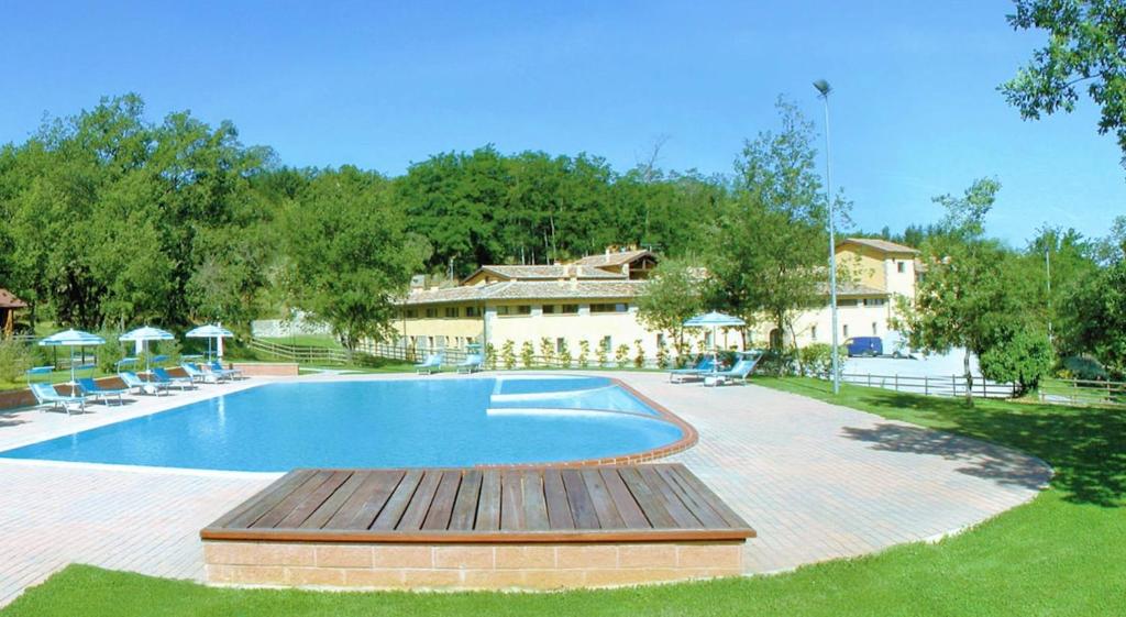 a swimming pool with a wooden deck next to a house at House Roberto by Holiday World in Castel del Piano