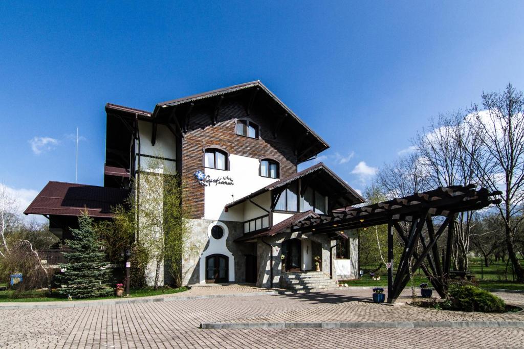 a large brick building with a black roof at Pensiunea Gentiana in Bran