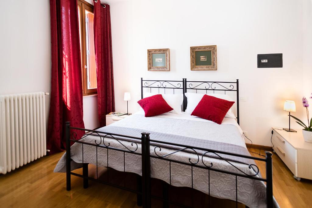 sypialnia z łóżkiem z czerwonymi poduszkami w obiekcie Verona Class ApartHotel "Residenze del Cuore" w Weronie