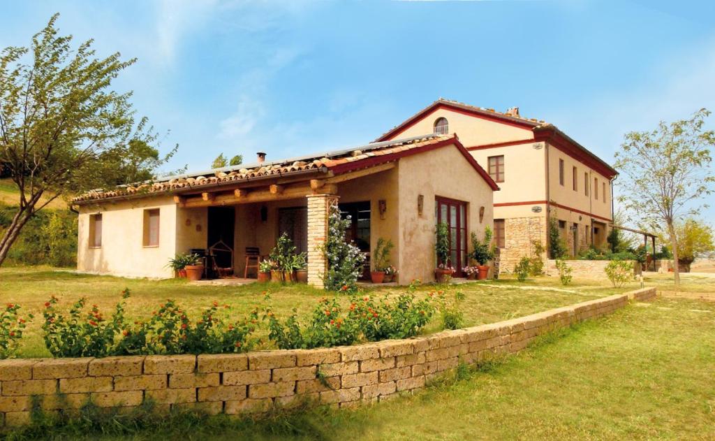 ein Haus mit einer Steinmauer davor in der Unterkunft Casa Montale in Montecarotto