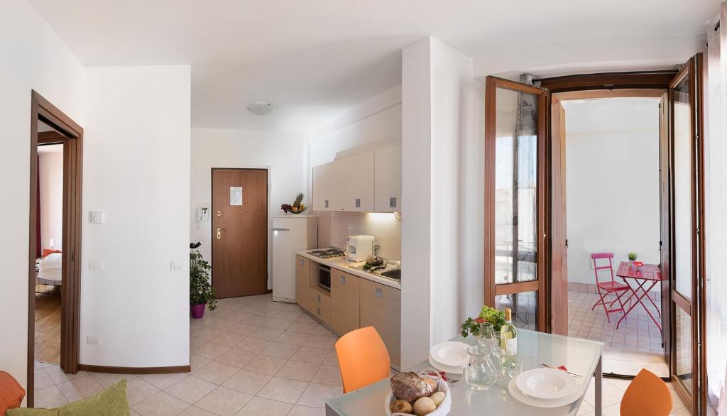 kuchnia i jadalnia ze stołem i krzesłami w obiekcie Verona Class ApartHotel "Residenze del Cuore" w Weronie