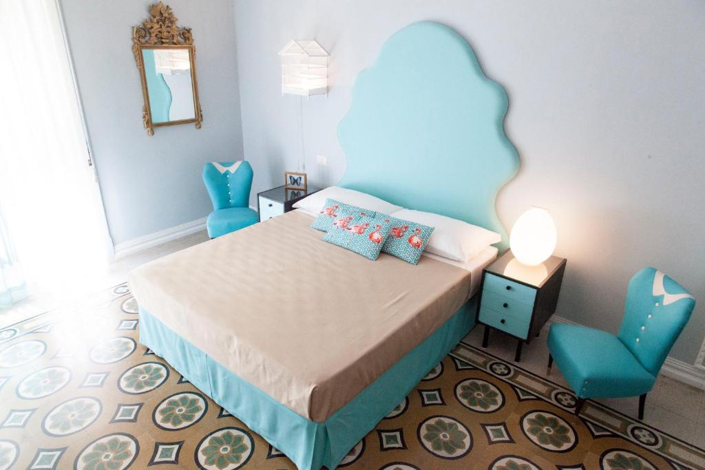 Naftalina Rooms في تيرمولي: غرفة نوم مع سرير مع اللوح الأمامي الأزرق