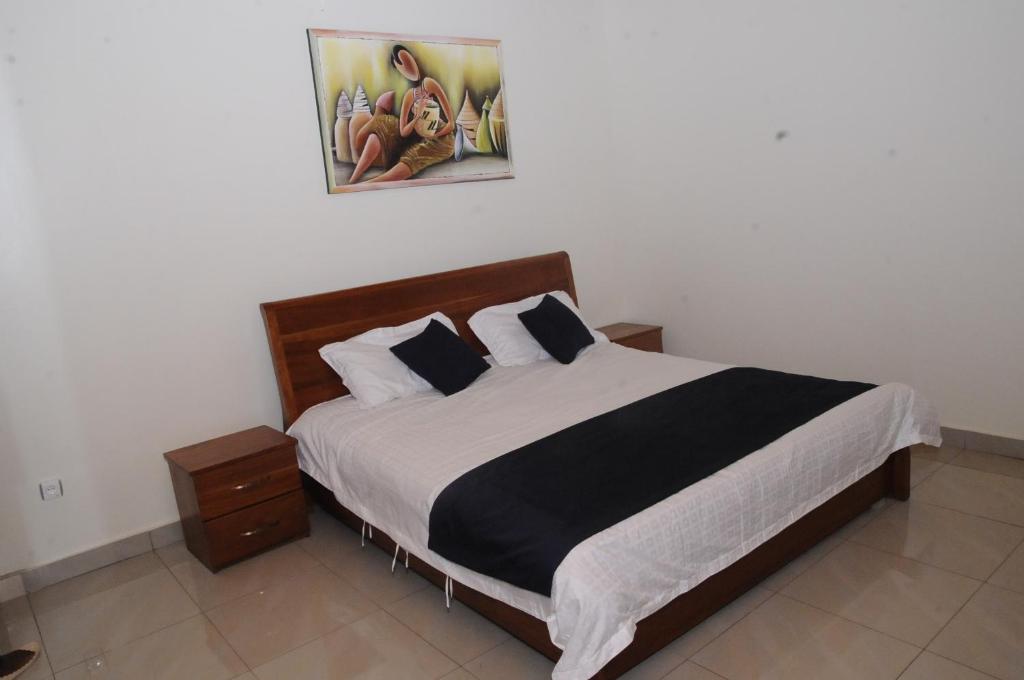 a bedroom with a large bed with black and white sheets at Keva Guest House in Kigali