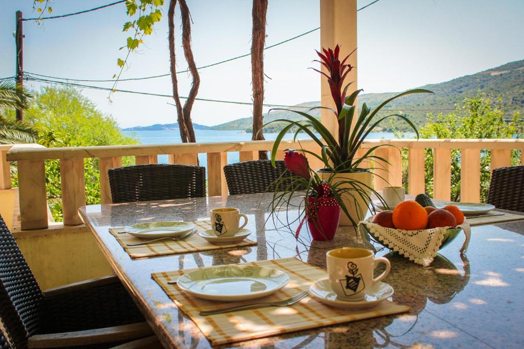 a table with coffee cups and fruit on a balcony at Apartments Bilaja in Marina