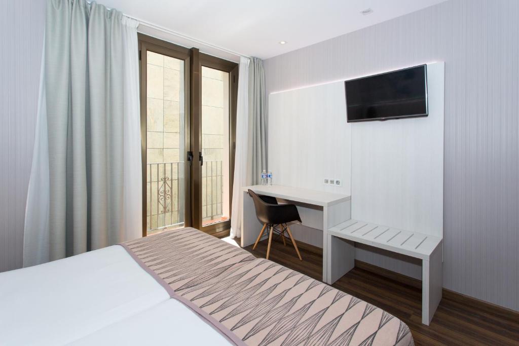 Posteľ alebo postele v izbe v ubytovaní Hostal Operaramblas