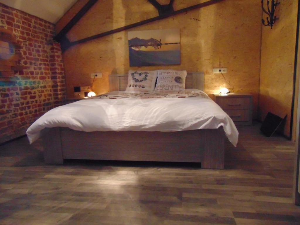 Lomalienne في Geer: غرفة نوم بسرير كبير عليها شراشف ووسائد بيضاء