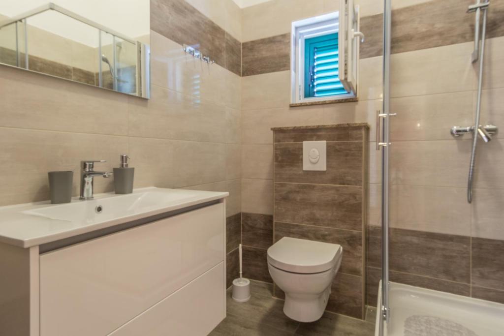 a bathroom with a toilet and a sink and a shower at Stara Kuća Apartments in Šimuni