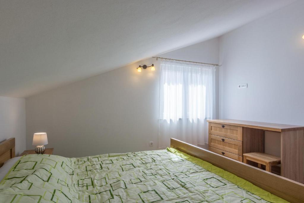 a bedroom with a bed and a dresser and a window at Stara Kuća Apartments in Šimuni