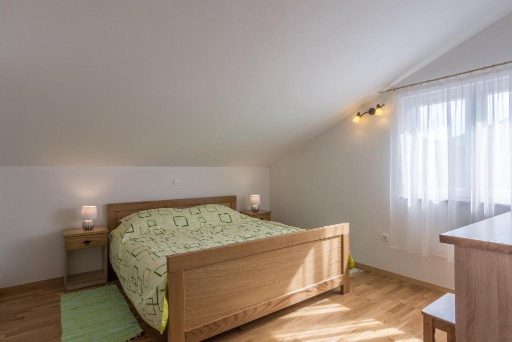 a small bedroom with a bed and a window at Stara Kuća Apartments in Šimuni