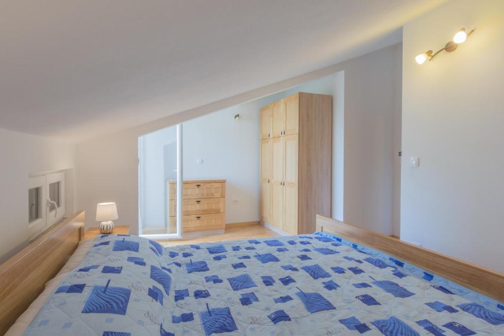 a bedroom with a large bed and a dresser at Stara Kuća Apartments in Šimuni