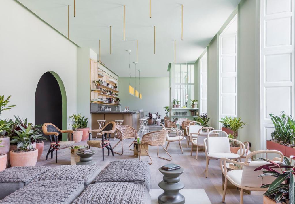 een kamer met stoelen, tafels en planten bij Eden Locke in Edinburgh