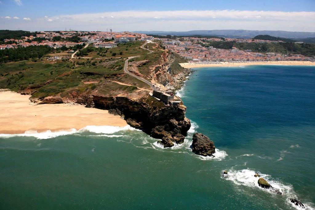 una vista aerea su una spiaggia e sull'oceano di Apartamentos das Avós- Wimari a Nazaré