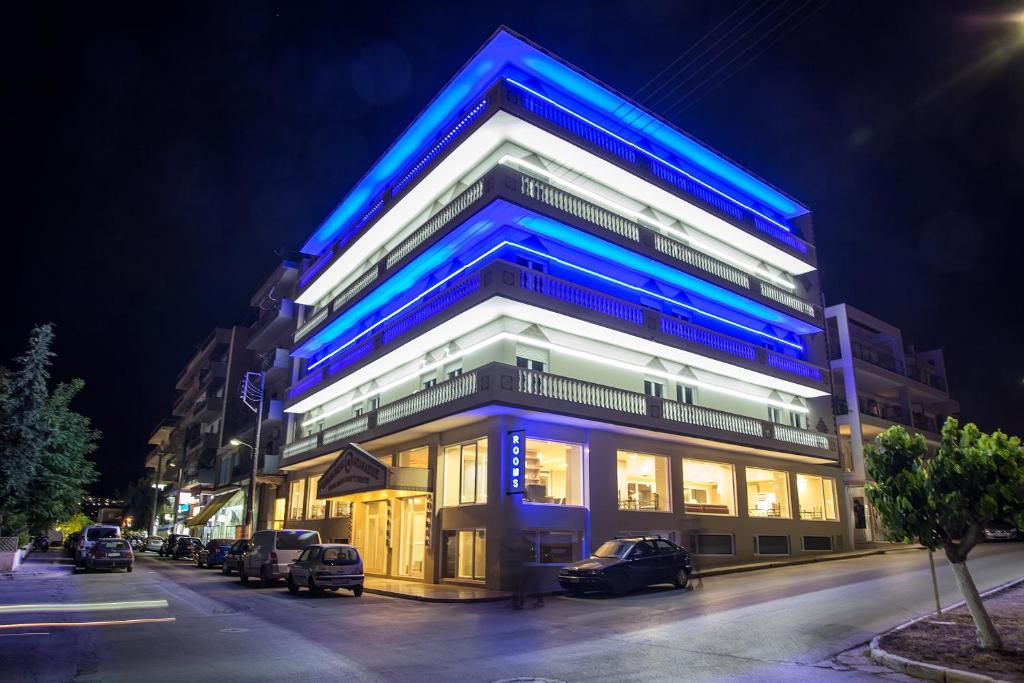 un edificio azul con coches estacionados frente a él en Nikolakakis Rooms Lavrio en Lávrion