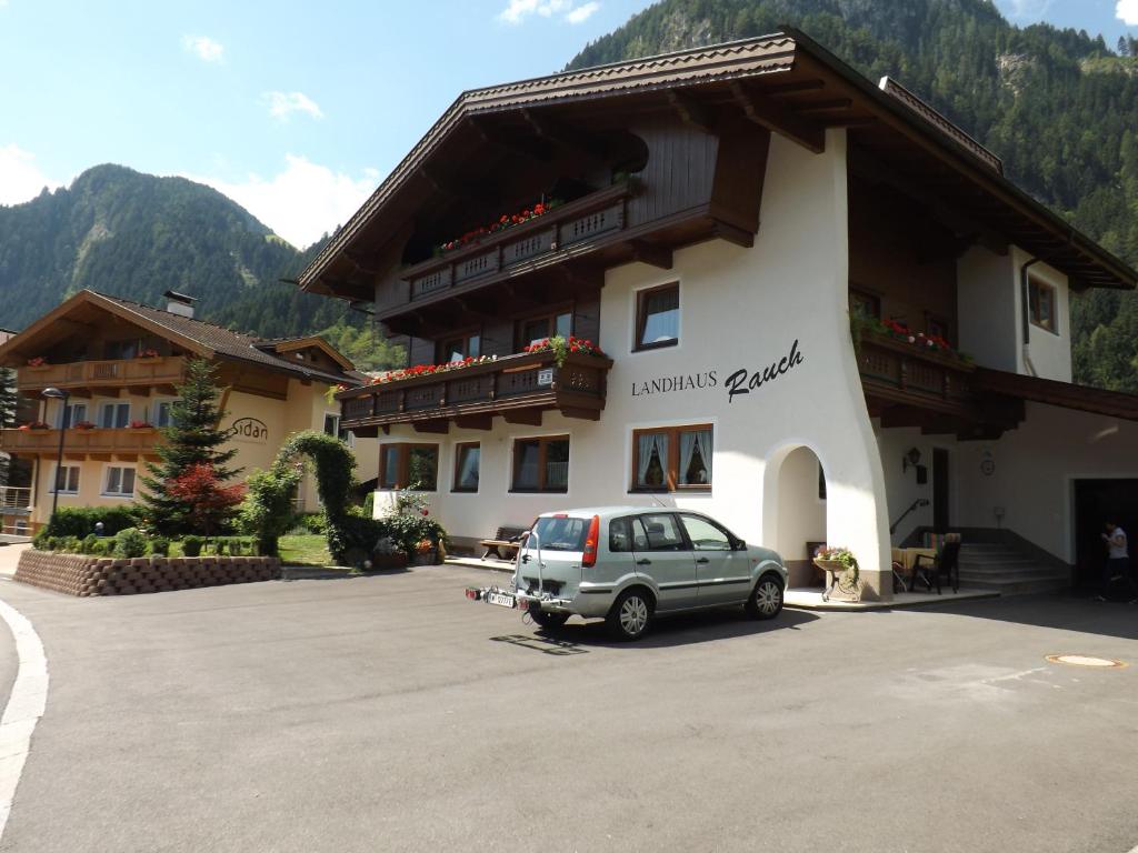 a car parked in a parking lot in front of a building at Landhaus Rauch in Schwendau