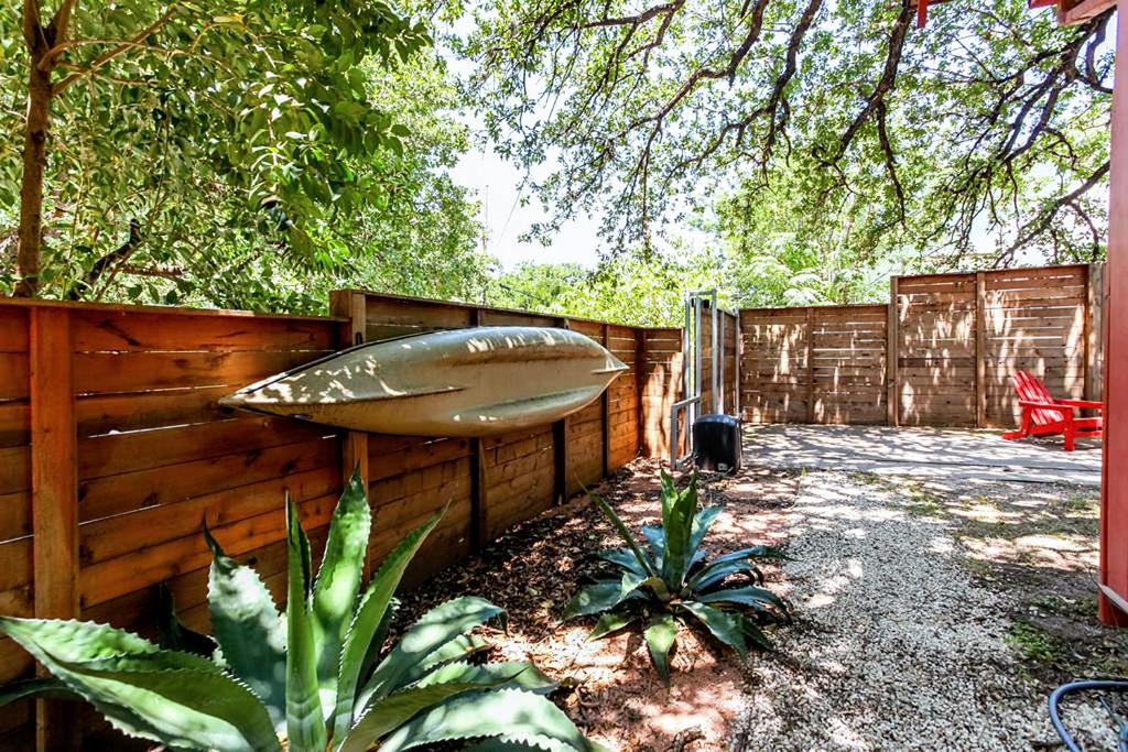 ein Holzzaun mit einem Surfbrett darauf in der Unterkunft Tiny House in Austin