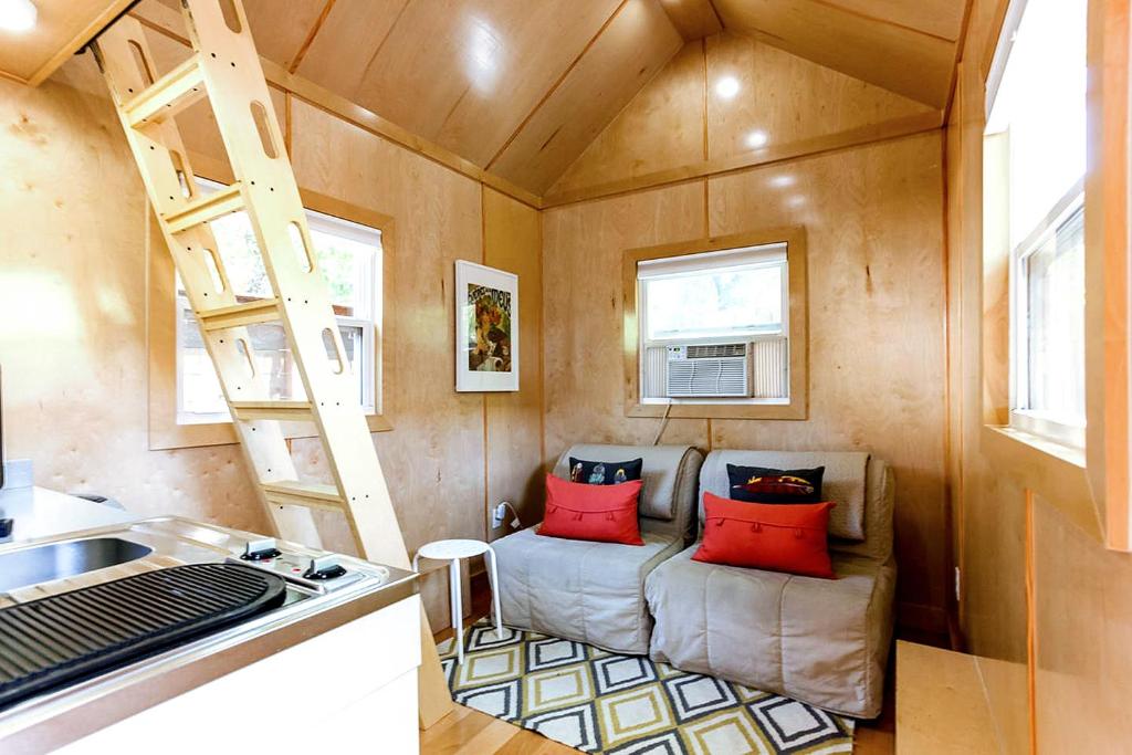 ein winziges Haus mit einer Couch und einer Leiter in der Unterkunft Tiny House in Austin