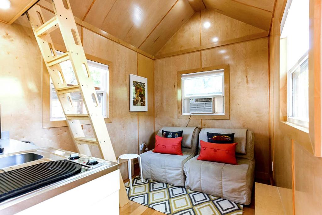 a tiny house with a couch and a ladder at Tiny House in Austin