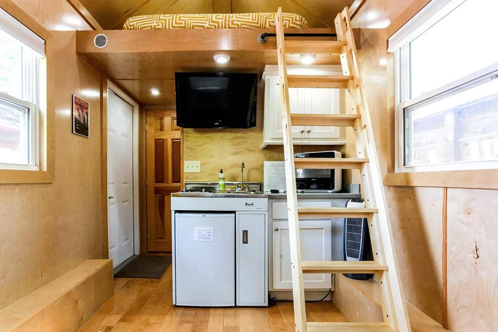 ein kleines Haus mit einer Küche und einer Leiter in der Unterkunft Tiny House in Austin
