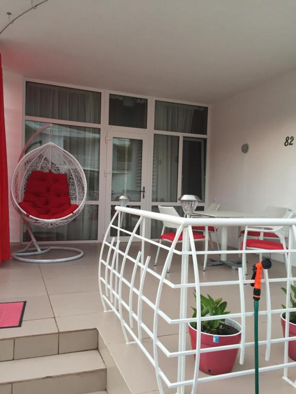 a living room with a spiral staircase and a red chair at Apartment near the sea in Gribovka