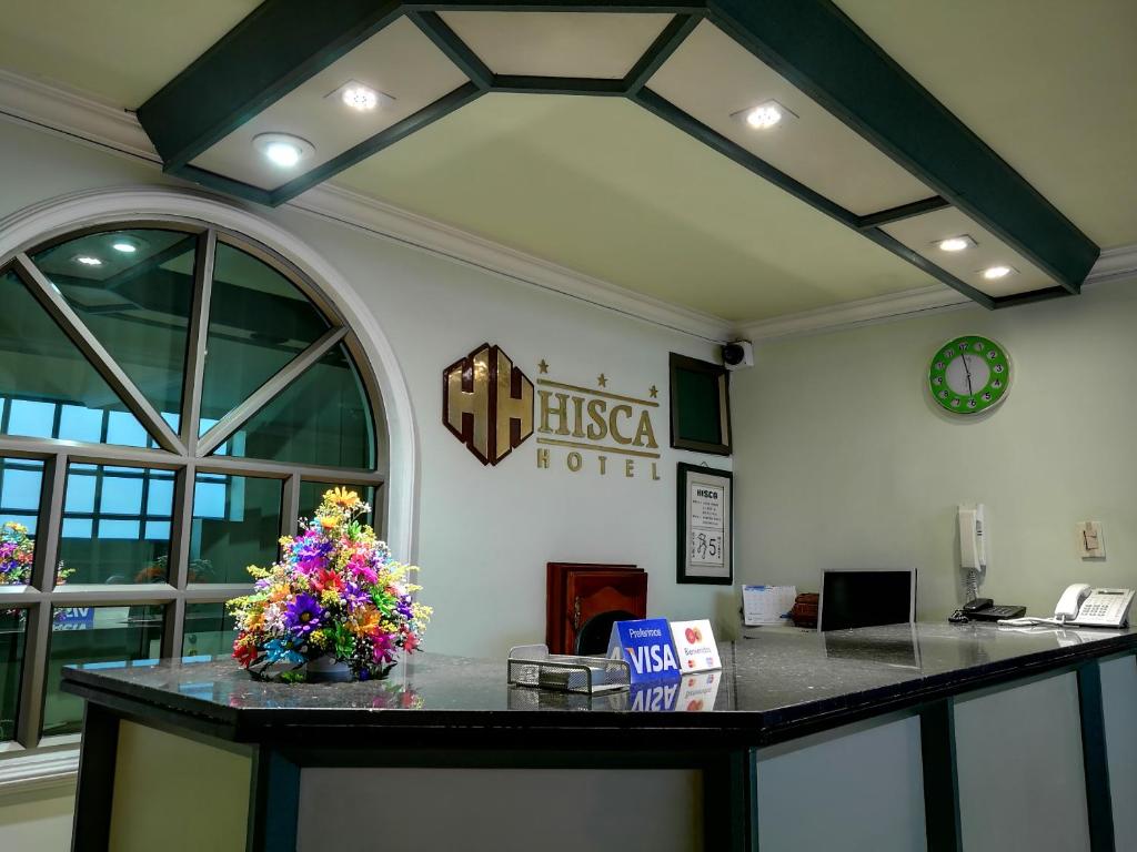una oficina con un mostrador de recepción con flores. en Hisca Hotel, en Duitama